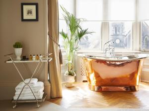 爱丁堡The Roseate Edinburgh - Small Luxury Hotels of the World的浴缸位于带窗户的房间内