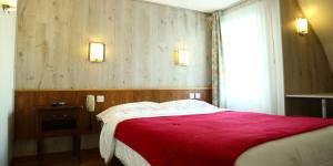 朗吉斯白房子餐厅酒店的一间卧室配有一张带红色毯子的大床