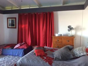 普纳奥亚Bungalow Premium Tahiti的一间卧室设有两张床和红色窗帘