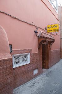 马拉喀什斋图内酒店的砖砌的建筑,有门,上面有标志