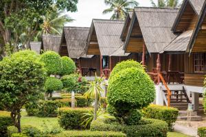 湄南海滩香格里拉哈简易别墅酒店的一座带花园、树木和灌木的度假村