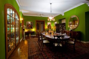 圣彼得教区Colleton Great House的一间设有桌子和绿色墙壁的用餐室