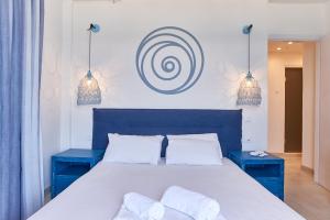 阿吉奥斯伊欧尼斯Kelly Hotel Agios Ioannis Pelion的一间卧室配有蓝色的床和两张蓝色的桌子