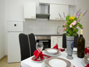 赞吉纳Apartments Vesela的厨房配有带酒杯和鲜花的桌子