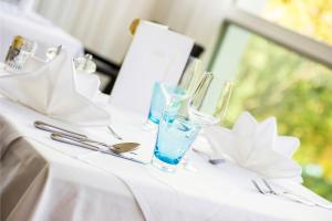 梅拉诺桑恩豪夫酒店的一张带玻璃杯和银器的白色桌子