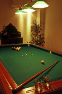 坎尼吉翁斯特尔海洋酒店的一张带球和两杯玻璃的绿色台球桌
