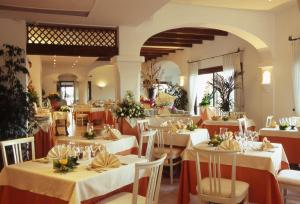 坎尼吉翁斯特尔海洋酒店的餐厅设有白色的桌椅和鲜花