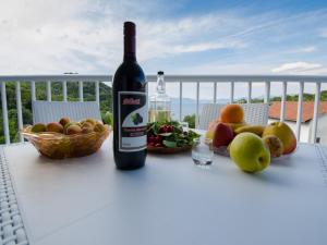 赞吉纳Apartments Vesela的一瓶葡萄酒和一碗水果放在桌子上