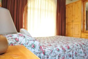 MunxarSt Nicholas Crt的一间卧室配有一张床和一张桌子上的台灯