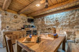 杜格普利耶Modern and Cozy little House Mia的厨房配有木桌和石墙