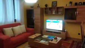洛乌Apartamento Loiu的客厅配有红色沙发和平面电视