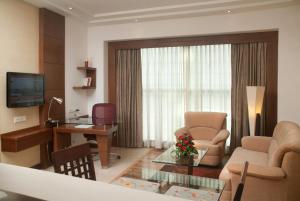 大诺伊达大诺伊达萨沃伊套房酒店的客厅配有桌椅和书桌。