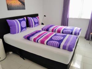 梅尔斯堡Ferienwohnung im Atelierhaus的一张带紫色和紫色枕头的床