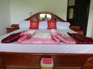 海岸角Paradise Ocean Resort的一张带红色枕头和粉红色棉被的床