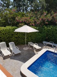罗萨斯Casa Lorca的游泳池旁的遮阳伞和椅子