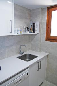 莱斯卡拉Albatros House的白色的厨房设有水槽和窗户