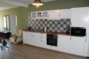 普鲁滕Ferienhaus Lilli的厨房配有白色橱柜和炉灶。