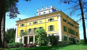 SyamLa Villa Palladienne - Château de Syam的前面有长椅的大型黄色建筑
