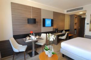 米兰iH Hotels Milano Lorenteggio的酒店客房 - 带一张床和用餐室