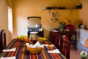 科塔卡奇Loma Wasi Alojamiento Rural Indígena en Cotacachi的厨房配有带水果碗的桌子