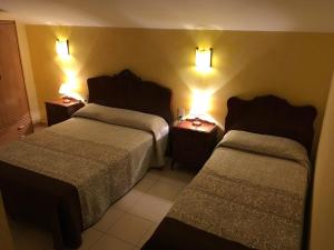 圣费柳-德帕利亚罗尔斯La Badia的酒店客房,设有两张床,墙上有灯