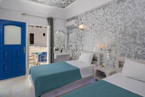 费拉凤凰公寓式酒店的一间卧室设有两张床和一扇蓝色的门