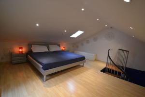 列日Maisonnette的一间卧室设有蓝色的床和楼梯。