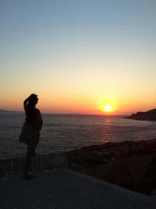 ArkoiArki Island-Katsavidis的站在墙上看着日落的女人