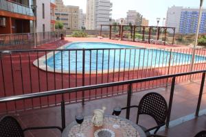 奥罗佩萨德尔马Residencial Algaida的一个带桌子和游泳池的阳台