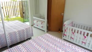 因巴塞Flat Village Imbassai Solaris的一间设有两张婴儿床的房间