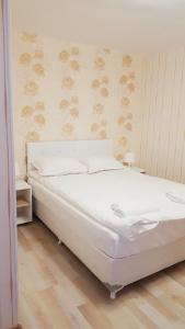 希典Villa Rusto的卧室铺有木地板,配有一张白色的床。