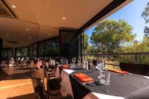 国王峡谷Discovery Resorts - Kings Canyon的餐厅设有桌椅和大窗户。