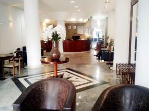 迪维诺波利斯River Palace Hotel的大堂设有两把椅子和花瓶