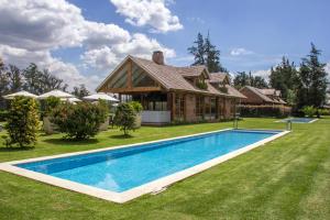 PuemboLa Palma Polo Hotel - Airport Area的庭院中带游泳池的房子
