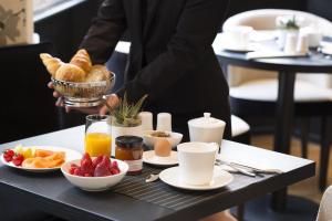 斯特拉斯堡十五号精品酒店 的把早餐盘放在桌子上的人