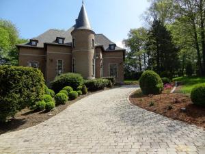 Montignies-le-TilleulLe chateau des eglantines的通往带塔楼的房子的砖车道