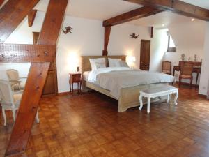 Montignies-le-TilleulLe chateau des eglantines的卧室配有一张床和一张桌子及椅子