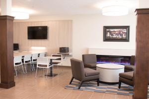 史普林维尔Microtel Inn & Suites by Wyndham Springville的一间设有桌椅和电视的等候室