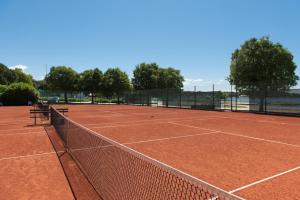 罗维尼Maistra Select Villas Rubin Resort的网球场,上面有网和长凳