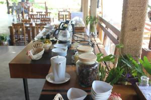 瑶亚岛瑶亚岛山坡度假村的长桌子上摆着杯子和盘子