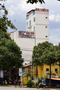邦美蜀洪王酒店的一座高大的白色建筑,旁边设有标志