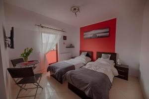 雅罗斯瓦维茨4 strony świata的一间卧室设有两张床和红色的墙壁