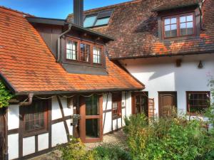 莱瑙Ferienhaus-Schwarzwald-Imbirkenweg-bei-Strassburg-Europapark-fuer-1-12-Personen的一座红色屋顶的白色旧房子