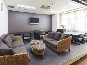 高知米娜托娅酒店的带沙发和桌子的客厅以及电视。
