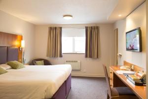 曼彻斯特你好酒店的酒店客房设有两张床、一张书桌和一个窗户。