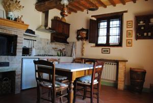 圣奎里科-多尔恰La Moiana的厨房配有桌椅和壁炉。