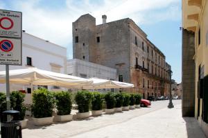 卡萨拉诺Palazzo Gallo的街道上一排灌木丛和遮阳伞,有一座建筑