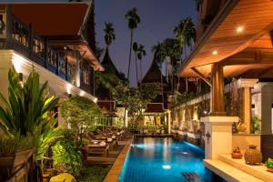 曼谷戴维斯泰国之家别墅的一座位于一座带度假村的建筑中间的游泳池