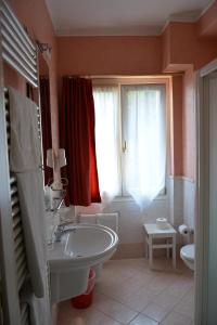 加尔尼亚诺Hotel La Terrazzina的带浴缸、水槽和窗户的浴室