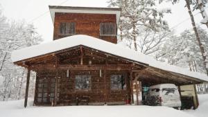 白马村白马和谐之家度假屋的小木屋,屋顶上积雪